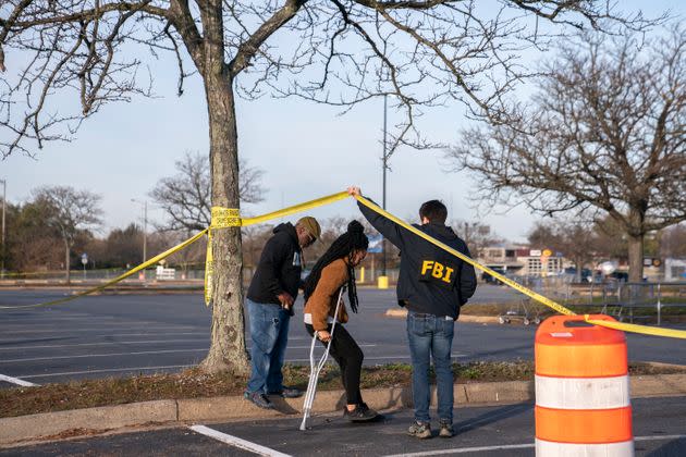 Prioleau, center, speaks to a member of the FBI on Thursday after the fatal shooting that left six people dead.