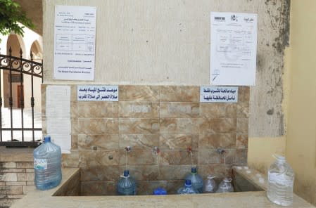 Water gallons are filled during a water shortage in Tripoli