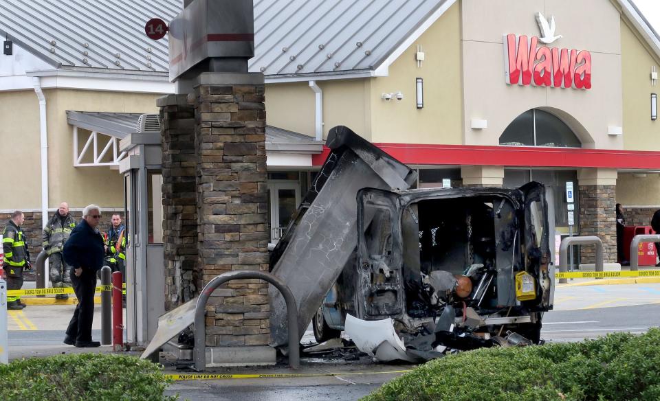 A burned plumbing company van sits under the gas awning at the Wawa on Route 34 in Wall Township, NJ, Tuesday, March 1, 2022.  The store and gas pumps remain closed after the fire.