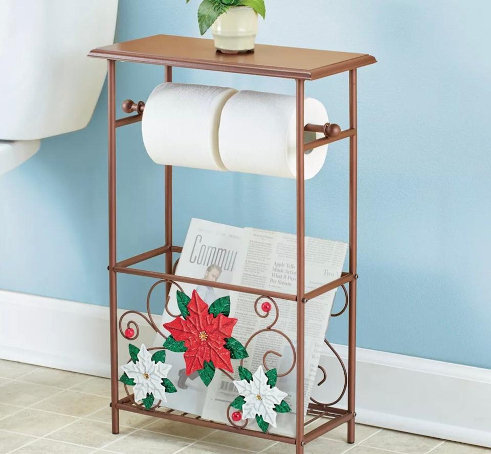 Metal holiday toilet paper holder holding two rolls of toilet paper.