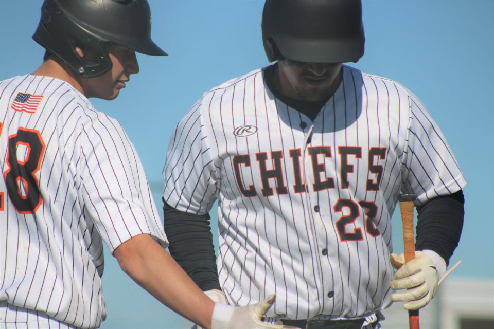 Cheboygan sophomore Sean Postula (28) gets congratulated by sophomore teammate James Charboneau (18) after scoring a run during a varsity baseball doubleheader against Sault Ste. Marie at home on Wednesday.