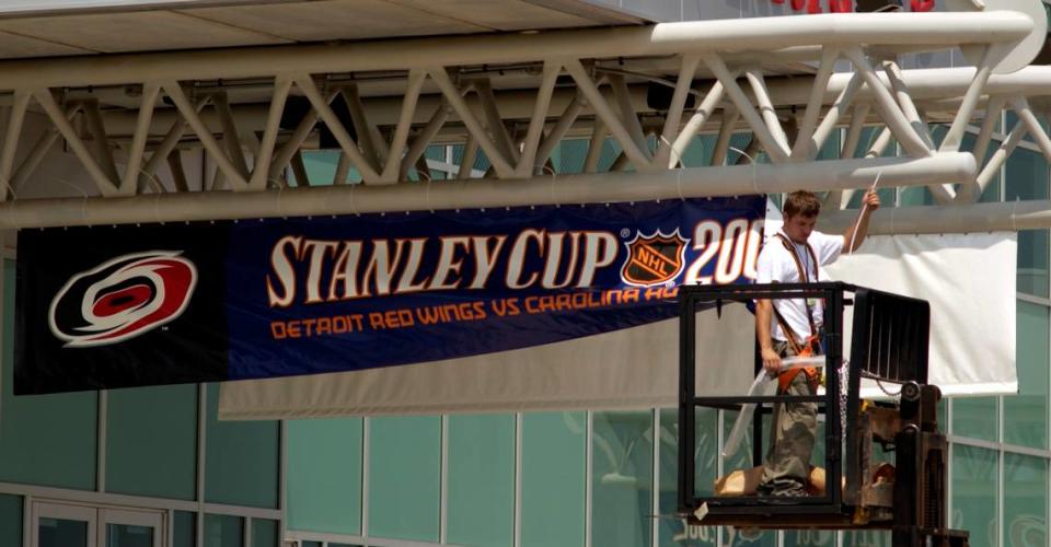 John Sandor, Operations Supervisor for the Carolina Hurricanes’ Changeover Crew, puts up banners in 2006 at the Entertainment and Sports Arena heralding the coming contest with the Detroit Red Wings for the Stanley Cup.