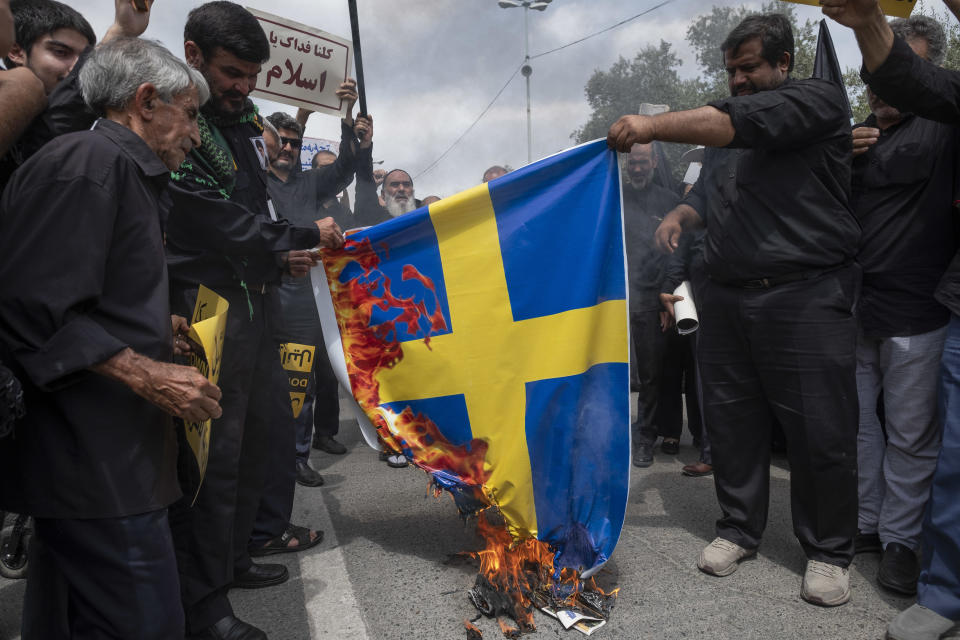 Iranian protesters burn a Swedish flag during a protest against the desecration of the Quran at demonstrations in the Swedish capital Stockholm, at the Imam Khomeini Grand Mosque in Tehran, Iran, July 21, 2023. / Credit: Morteza Nikoubazl/NurPhoto/Getty