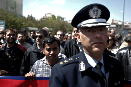 FILE PHOTO: A migrant who lives in Greece takes part in a rally protesting against a shooting incident that took place in the town of Manolada, in Athens, Greece, April 18, 2013. REUTERS/Yorgos Karahalis/File Photo