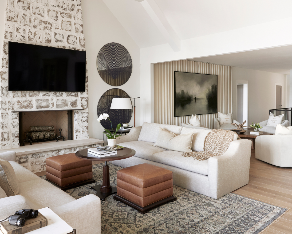  A neutral living room with brown leather stools. 