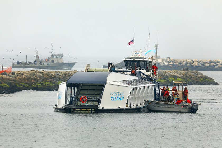 Los Angeles, California-Oct. 6, 2022-The Ballona Creek trash interceptor is positioned in the Ballona Creek in Playa del Rey area of Los Angeles on Oct. 6, 2021. The interceptor is a 2-year pilot project by the Los Angeles County Flood District and The Ocean Cleanup, a Dutch nonprofit, to collect trash before it goes into the ocean. The Ballona Creek is a nine-mile-long waterway that protects 1.5 million residents from flooding. Each year, more than 30 tons of trash, litter and debris enters Balloon Creek, carried by urban runoff from city streets. The cost of designing and permitting is estimated at approximately $1.3 million dollars. Installment workers position the interceptor in the center of the channel. (Carolyn Cole / Los Angeles Times)