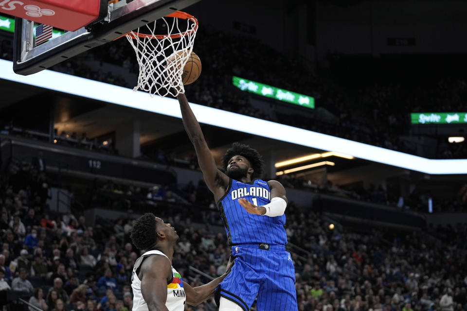 Orlando Magic forward Jonathan Isaac, right, shoots while defended by Minnesota Timberwolves guard Anthony Edwards during the second half of an NBA basketball game, Friday, Feb. 3, 2023, in Minneapolis. (AP Photo/Abbie Parr)