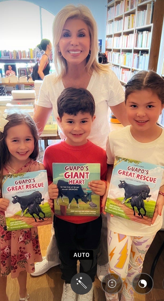 Part-time Coachella Valley resident and author/journalist Janet Zappala poses with local students holding her book "Guapo’s Great Rescue."