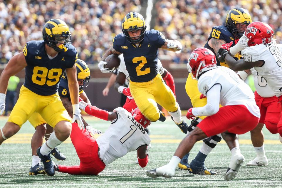 Michigan running back Blake Corum (2) runs for a first down against UNLV defensive back Jerrae Williams (1) during the first half at Michigan Stadium in Ann Arbor on Saturday, Sept. 9, 2023.