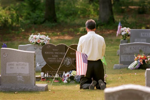 After a news conference announcing that police had identified Richard Marc Evonitz as the killer of Kristin and Kati Lisk, an unidentified FBI agent kneels by the sisters' graves on Aug. 13, 2002.