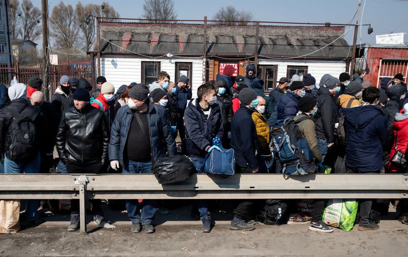 People queue to cross to Ukraine at the border crossing in Dorohusk