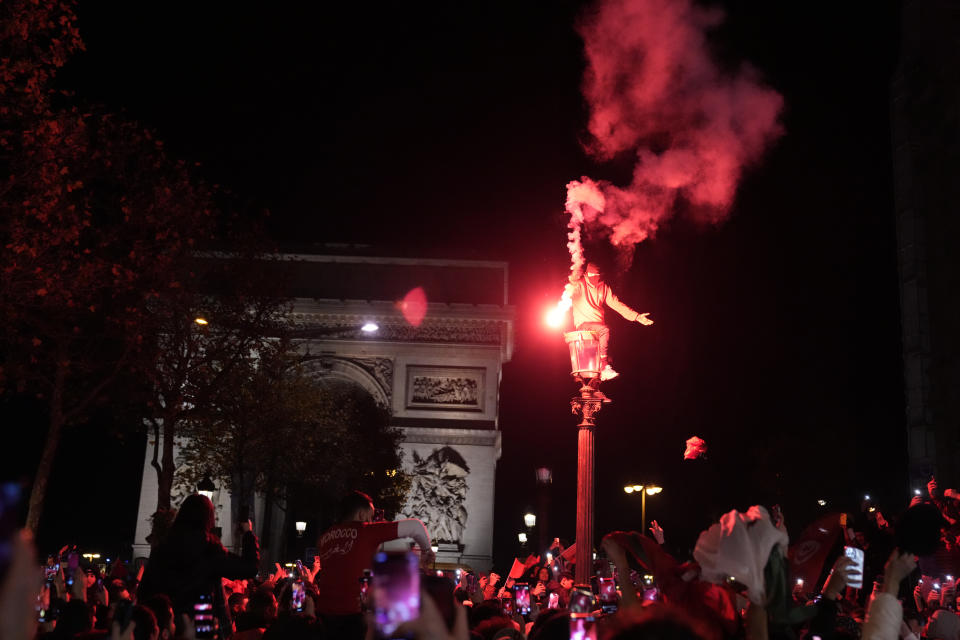 FILE - Morocco soccer fans celebrate their team's victory on the Champs-Elysees avenue after the World Cup quarterfinal soccer match between Morocco and Portugal Saturday, Dec. 10, 2022 in Paris. Every meeting of Morocco and France, the North African country's former colonial ruler, meet in an international tournament, emotions run high among players and their supporters. Family tales of colonial past emerge among the Moroccans and stories of harsh life of immigrants in France bubble up with questions of national loyalty pop up to French players with immigrant roots. (AP Photo/Francois Mori, File)