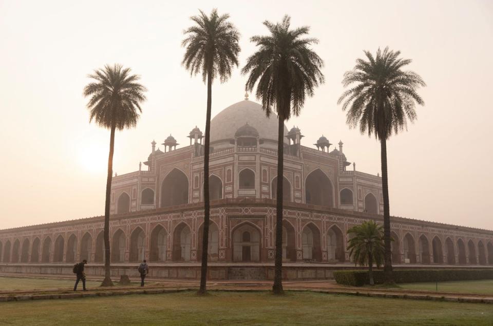 People walk in front of Humayun’s Tomb under morning smog (Reuters)