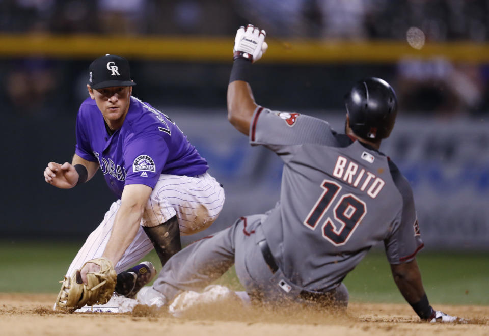 Colorado Rockies second baseman DJ LeMahieu, left, applies the tag to Arizona Diamondbacks' Socrates Brito as he slides into second base while trying to stretch a single into a double in the eighth inning of a baseball game Monday, Sept. 10, 2018, in Denver. The Rockies won 13-2. (AP Photo/David Zalubowski)