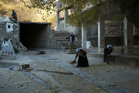 Yazidi women sweep the ground of a Yazidi temple in Lalish, Shikhan province, Kurdistan, northern Iraq, December 7, 2016. REUTERS/Ari Jalal