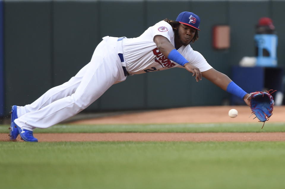 In this Tuesday, July 31, 2018, photo, Buffalo Bisons third baseman Vladimir Guerrero Jr. dives for the ball on a single by Lehigh Valley IronPigs' Aaron Altherr during first inning of a Triple-A minor league baseball game in Buffalo, N.Y. The Toronto Blue Jays will promote top prospect Vladimir Guerrero Jr. before their game against the Oakland Athletics, on Friday, April 26. (Nathan Denette/The Canadian Press via AP)
