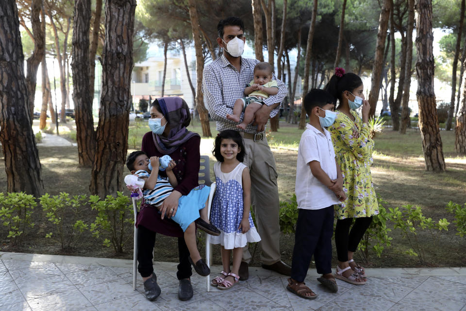 An Afghan family gather at a resort which is accommodated Afghan refugees in Golem, 45 kilometres (30 miles) west of the capital Tirana, Friday, Aug. 27, 2021. Albania on Friday housed its first group of Afghan evacuees who made it out of their country despite days of chaos near the Kabul airport, including an attack claimed by the Islamic State group. (AP Photo/Franc Zhurda)