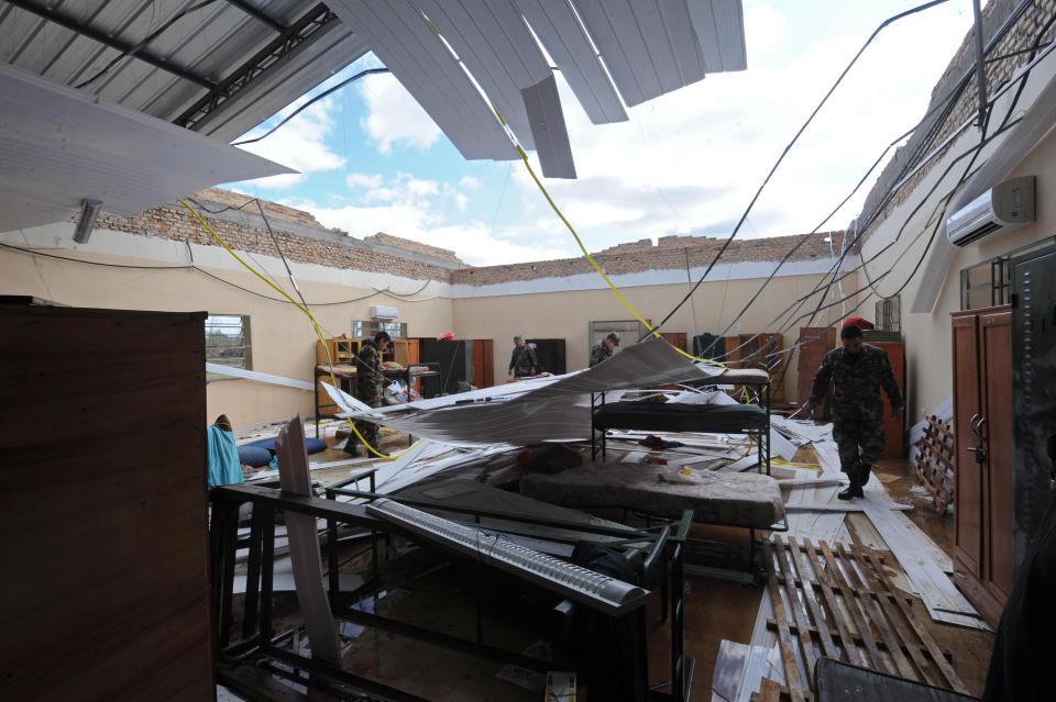 Officers inspect a Paraguayan Army Logistic Command dormitory where four military cadets were killed when their roof caved in during an overnight storm, in Mariano Roque Alonso, Paraguay, Wednesday, Sept. 19, 2012. A powerful storm killed five people and injured 81 in Paraguay as a storm blew across the southern cone of South America, ripping the roofs off of ramshackle homes and leaving thousands of people without shelter. (AP Photo)