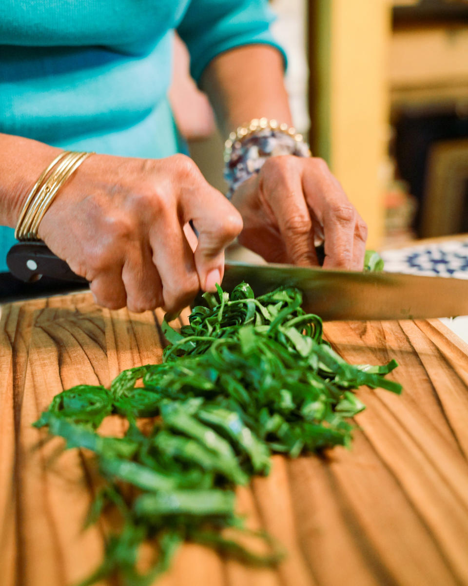 After washing and picking through the collard greens, Harris rolls them up and cuts them into ribbons. (Kara Birnbaum / TODAY)