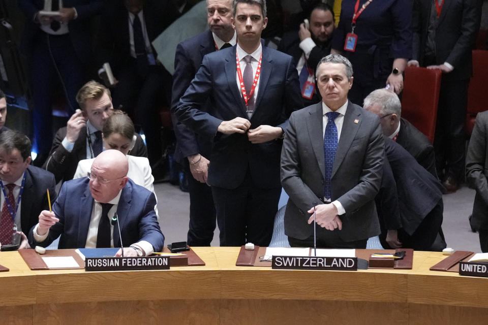 Russian ambassador to the United Nations Vasily Nebenzya, left, speaks while rising for a moment of silence at United Nations headquarters, Friday, Feb. 24, 2023. (AP Photo/Seth Wenig)