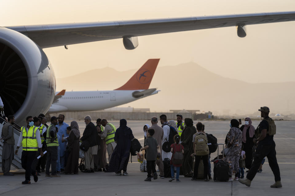 Foreigners board a Qatar Airways aircraft at the airport in Kabul, Afghanistan, Thursday, Sept. 9, 2021. Some 200 foreigners, including Americans, flew out of Afghanistan on an international commercial flight from Kabul airport on Thursday, the first such large-scale departure since U.S and foreign forces concluded their frantic withdrawal at the end of last month. (AP Photo/Bernat Armangue)