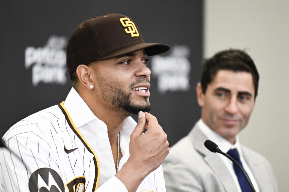 San Diego Padres' Xander Bogaerts, left, plays with his beard as general manager A.J. Preller looks on at a news conference held to announce that Bogaerts' $280 million, 11-year contact with the Padres has been finalized, Friday, Dec. 9, 2022, in San Diego. (AP Photo/Denis Poroy)