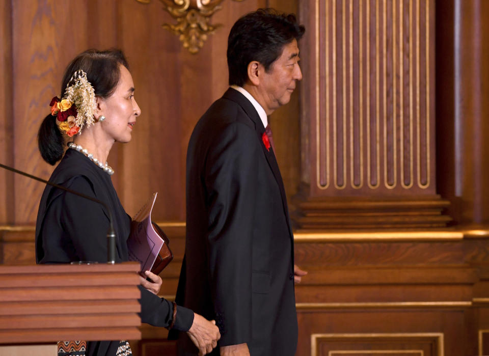 Myanmar's State Counsellor Aung San Suu Kyi, left, follows Japanese Prime Minister Shinzo Abe after their joint press remarks following their bilateral meeting at the Akasaka Palace state guest house in Tokyo Tuesday, Oct. 9, 2018. (Toshifumi Kitamura/Pool Photo via AP)