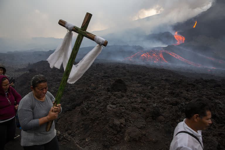 Una mujer lleva una cruz de madera durante una peregrinación para rezar para que el volcán Pacaya disminuya su actividad, en San Vicente Pacaya, Guatemala, el 5 de mayo. El volcán, a solo 50 kilómetros al sur de la capital de Guatemala, se volvió más activo a principios de febrero provocando graves daños

