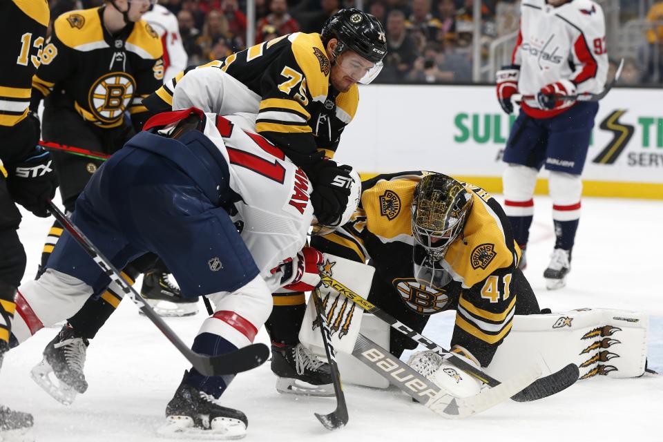 Boston Bruins' Jaroslav Halak (41) covers the puck as Connor Clifton (75) defends against Washington Capitals' Garnet Hathaway (21) during the second period of an NHL hockey game in Boston, Saturday, Nov. 16, 2019. (AP Photo/Michael Dwyer)