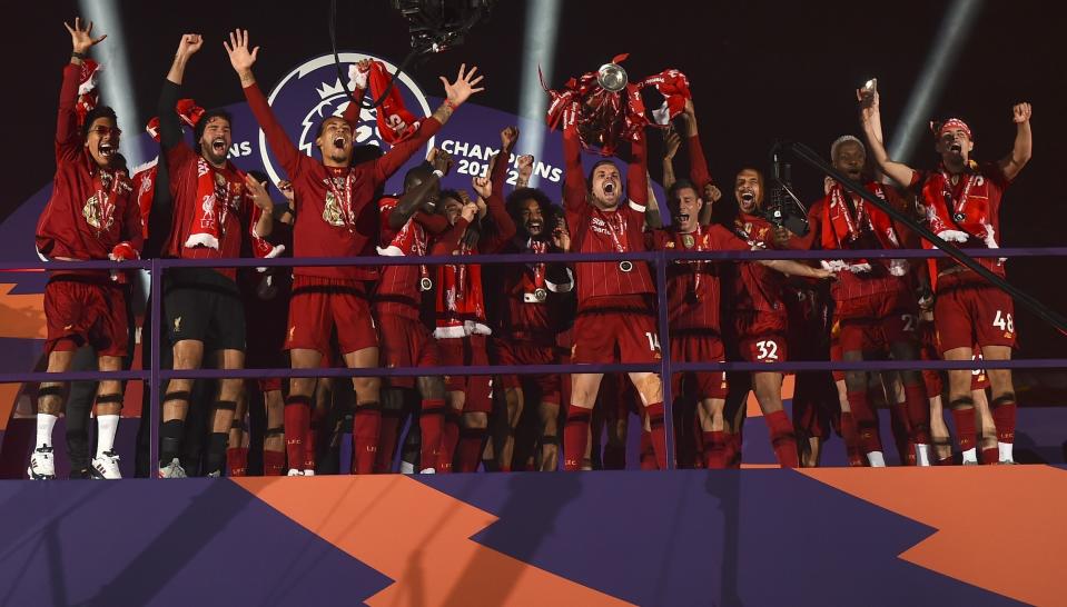 FILE - In this July 22, 2020, file photo, Liverpool's Jordan Henderson lifts the English Premier League trophy following their soccer match against Chelsea at Anfield Stadium in Liverpool, England. (Laurence Griffiths/Pool Photo via AP, File)