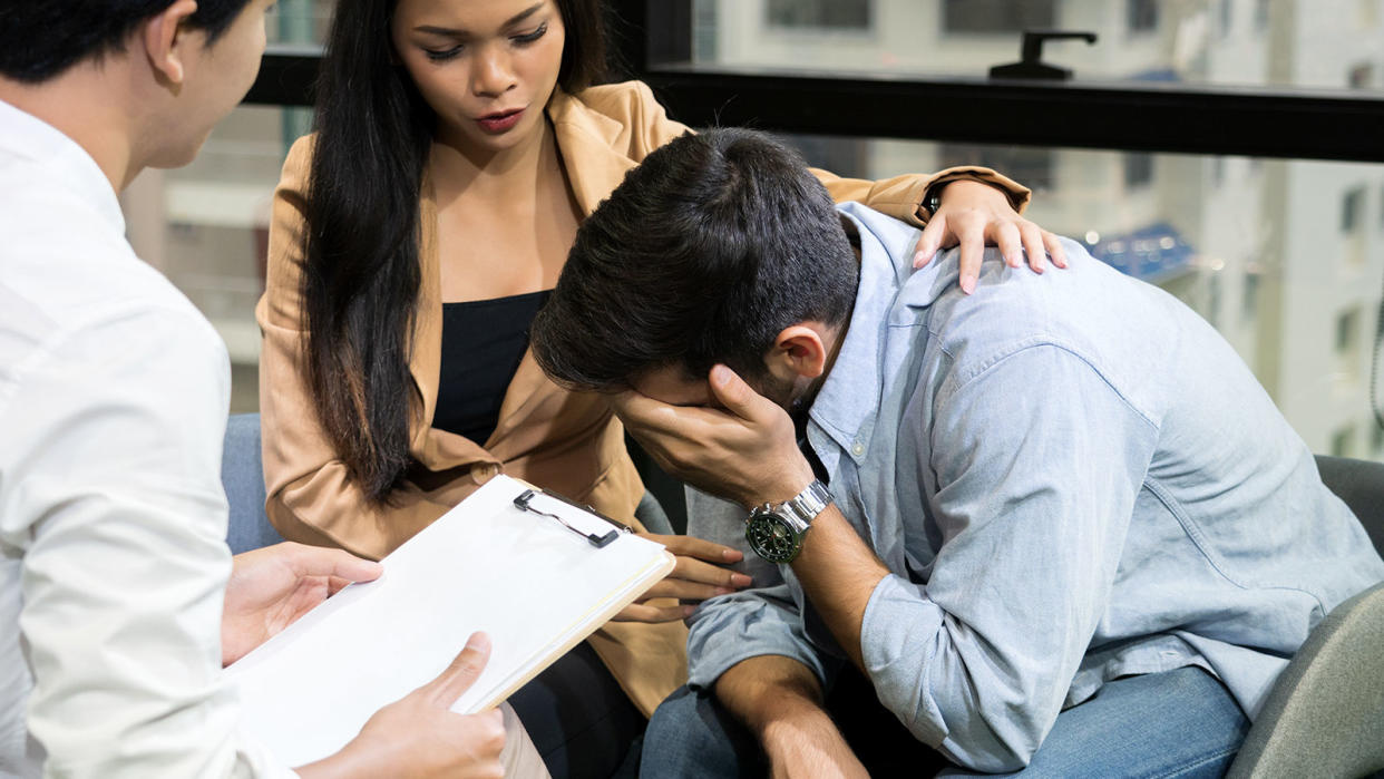 Man being comforted by a woman at counselling. (Photo: Getty Images)