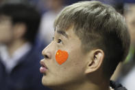 A fan with a heart-shaped Chinese national flag sticker on his face watches a preseason NBA basketball game between the Brooklyn Nets and Los Angeles Lakers at the Mercedes Benz Arena in Shanghai, China, Thursday, Oct. 10, 2019. (AP Photo)