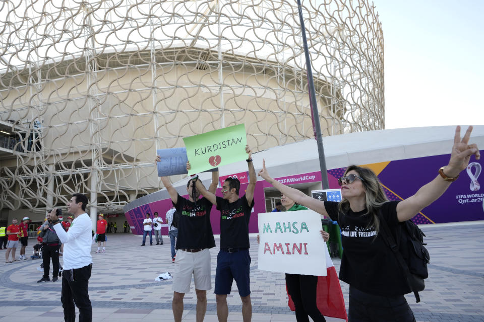 Protesters show banners reading "Kurdistan" and "Mahsa Amini" outside the Ahmad Bin Ali Stadium at the end of the World Cup group B soccer match between Wales and Iran, in Al Rayyan, Qatar, Friday, Nov. 25, 2022. (AP Photo/Alessandra Tarantino)