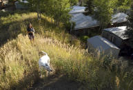 ADVANCE ON THURSDAY, SEPT. 12 FOR USE ANY TIME AFTER 3:01 A.M. SUNDAY SEPT 15 - Pitkin County Commissioner Patti Kay-Clapper walks with her dog near her home at the Smuggler Trailer Court outside Aspen, Colo., on Tuesday, Aug. 27, 2019. Clapper says that in the early 1980s, the county allowed Smuggler residents to own their homes and their lots in an effort to keep the community affordable. She now is trying to preserve the county's remaining mobile home parks as affordable housing. (AP Photo/Thomas Peipert)