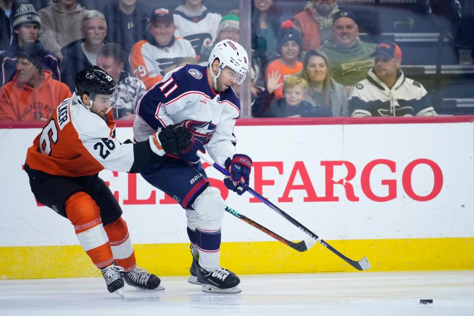 Columbus Blue Jackets' Adam Fantilli, right, tries to keep Philadelphia Flyers' Sean Walker away from the puck during the first period of an NHL hockey game, Sunday, Nov. 19, 2023, in Philadelphia. (AP Photo/Matt Slocum)