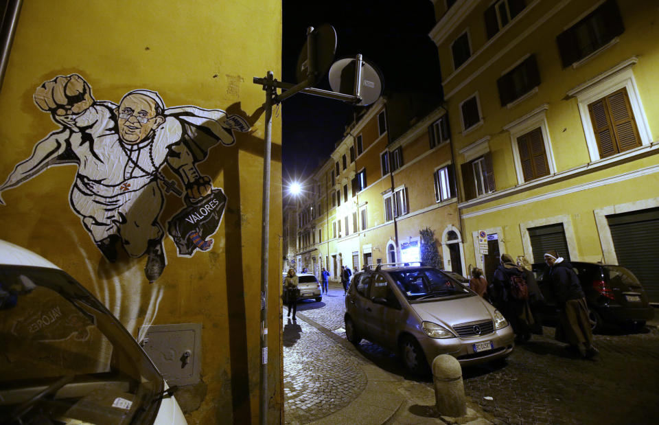 FILE - In this Tuesday, Jan. 28, 2014 file photo, a graffiti depicting Pope Francis as Superman and holding a bag with a writing which reads: "Values" is seen on a wall of the Borgo Pio district near St. Peter's Square in Rome. Pope Francis’ status as a superhero has bit the dust. Rome’s decorum police early Thursday, Jan. 30, 2014, scrubbed the wall near the Vatican where “SuperPope” had been displayed, showing Francis as Superman in flight and clutching his black satchel of values to spread to the world. Artist Mauro Pallotta had put the image up on Monday in homage to Francis. Pallotta’s agent, Margaret Porpiglia said Thursday the artist is now hoping to avoid a city fine but is considering making a street art piece depicting the “anti-hero” Rome Mayor Ignazio Marino. The white caped crusader pope, which was actually painted on paper and affixed to the wall with water-based glue, had drawn immense popular interest around the Borgo neighborhood of tiny cobble stoned streets near St. Peter’s Square. (AP Photo/Gregorio Borgia, File)