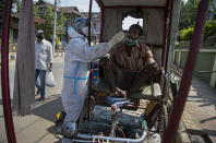 A health worker takes a nasal swab sample of a rickshaw driver during random testing for COVID-19 in a market in Gauhati, India, Friday, Oct. 16, 2020. India’s coronavirus fatalities jumped by 895 in the past 24 hours, a day after recording the lowest daily deaths of 680 in nearly three months. The Health Ministry on Friday also reported 63,371 new cases in the past 24 hours, raising India’s total to more than 7.3 million, second in the world behind the U.S. (AP Photo/Anupam Nath)
