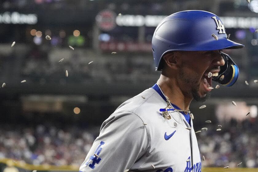 Los Angeles Dodgers' Mookie Betts gets sunflower seeds thrown at him as part of the celebration.