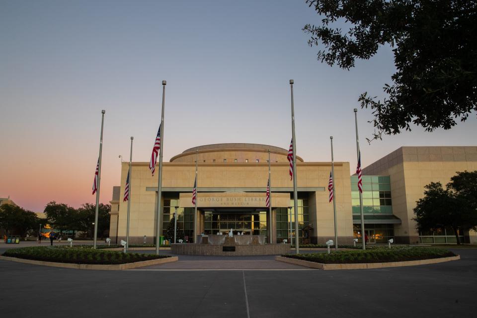 Flags flying at half-staff are seen at the entrance of the George Bush Presidential Library during sunset in College Station, Texas, on Dec. 1, 2018. (Photo: SUZANNE CORDEIRO via Getty Images)