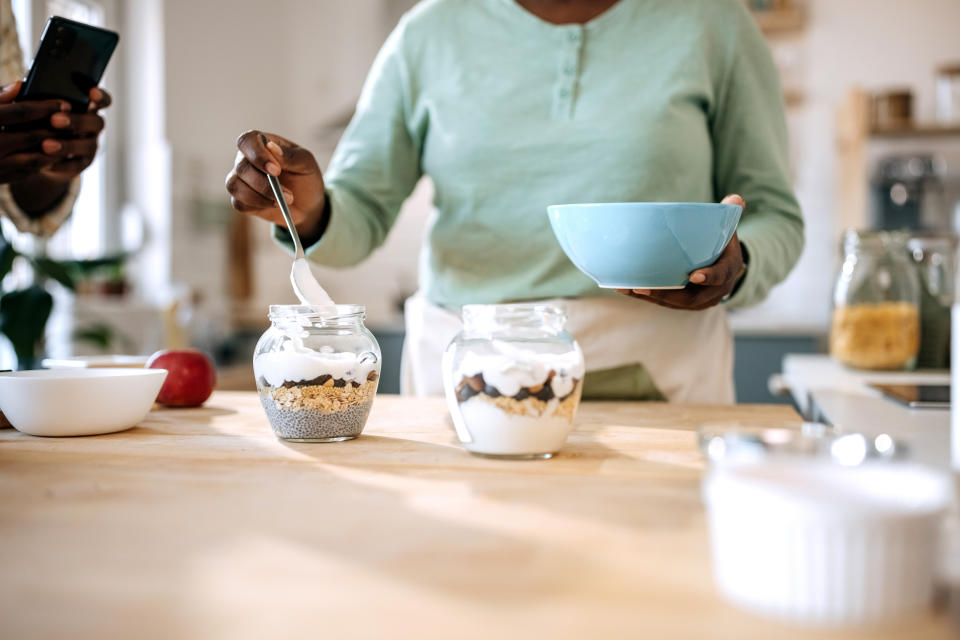 woman eating yoghurt and berries for breakfast