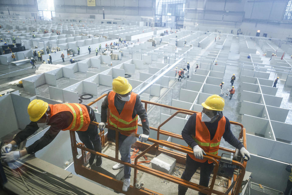 This photo taken on April 7, 2022 shows employees working at a makeshift hospital that will be used for Covid-19 coronavirus patients in Shanghai. China OUT  / AFP / CNS / -