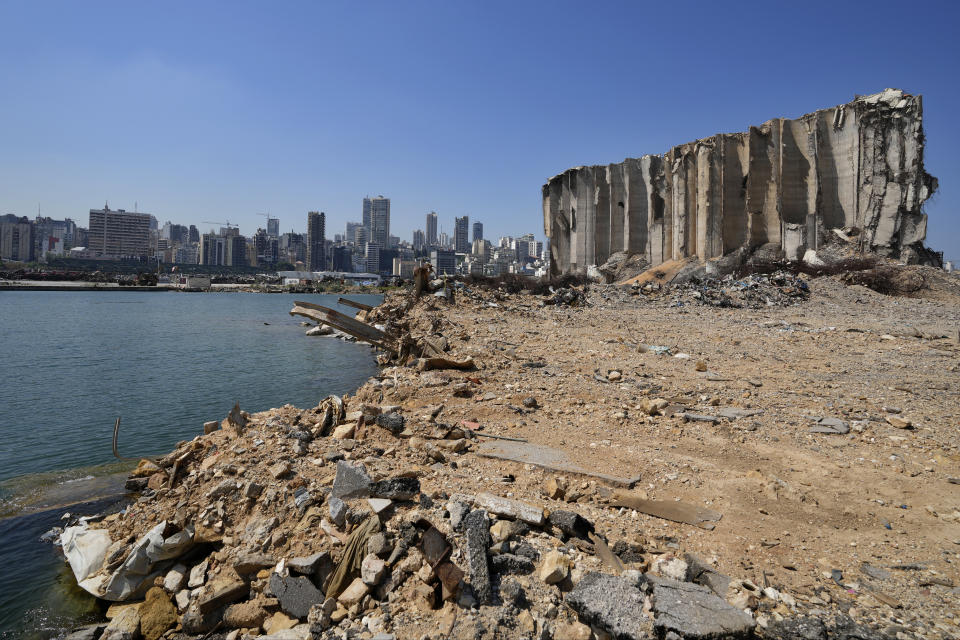 Rubble and debris remain around towering grain silos gutted in the site of a massive deadly explosion in August last year, at the port in Beirut, Lebanon, Tuesday, July 13, 2021. A year after the Aug. 4 deadly blast at Beirut port, families of the victims are consumed with winning justice for their loved ones and punishing Lebanon's political elite, blamed for causing the disaster through their corruption and neglect. (AP Photo/Hassan Ammar)