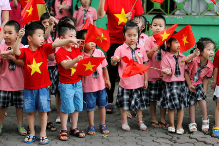 Children look at the motorcade transporting President Obama before an arrival ceremony at the presidential palace in Hanoi. REUTERS/Carlos Barria