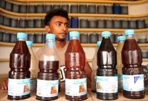 Yemeni beekeeper Ahmed Ali al-Adili with honey for sale in the Abs district of Hajjah province