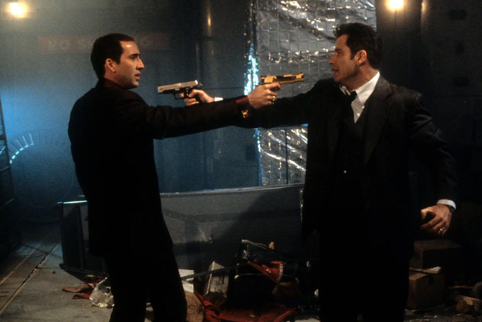 Nicolas Cage and John Travolta aiming guns at each other in a scene from the film 'Face/Off', 1997. (Photo by Touchstone/Getty Images)