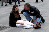 <p>A man helps an injured woman on the sidewalk in Times Square after a speeding vehicle struck pedestrians on the sidewalk in New York City on May 18, 2017. (Mike Segar/Reuters) </p>