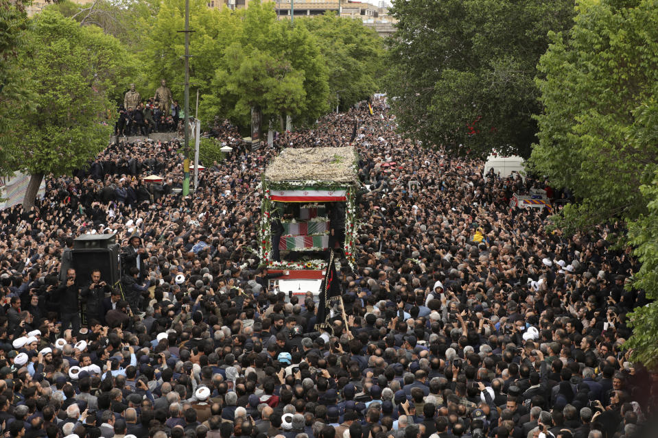 In this photo released by the Iranian Presidency Office, mourners gather around a truck carrying the flag-draped coffins of President Ebrahim Raisi and his companions who were killed in a helicopter crash on Sunday in a mountainous region of the country's northwest, in their funeral ceremony in the city of Tabriz, Iran, Tuesday, May 21, 2024. (Iranian Presidency Office via AP)