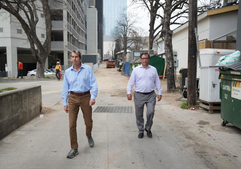 Tom Haider, left, a resident of the Shore Condominiums in the Rainey neighborhood, and condo General Manager Jim Reist walk in an alley behind the condos. “How are we going to get emergency vehicles in here?” Haider asks of the area's growing congestion. “That’s my biggest concern.”