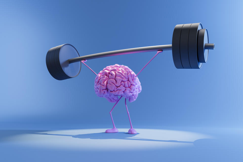 A 3D illustration of a pink brain with thin arms and legs lifting a heavy barbell, symbolizing mental strength and exercising the brain