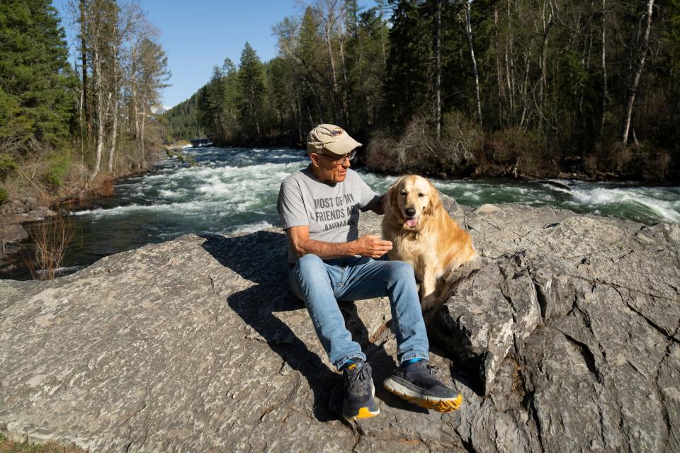 Jack Hanna sits with his service dog, Brassy, alongside the Swan River as they take their daily walk along the Bigfork Nature Trail near his Montana home last May. His family recently said Hanna has reached an advanced stage of Alzheimer's.